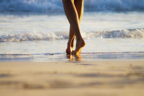 海辺を歩く女性の足